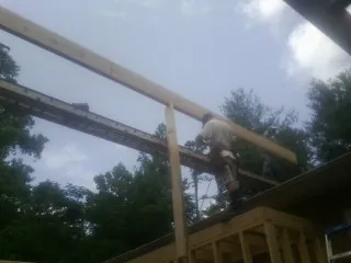 Carpenter setting a ridge beam over a new addition frame — Ice Dam Removal by Roofing Brothers in Conyngham