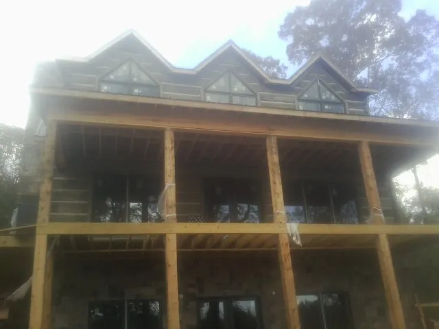 Dormers and porch framing on a large log home under construction — Roof Coating work by our crew in Conyngham