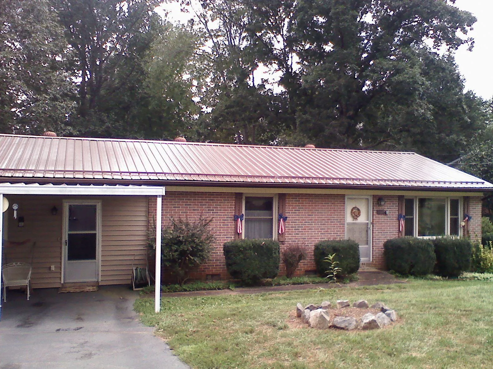 Bronze metal roof and carport on a brick ranch home — Roof Repair work by our crew in Conyngham